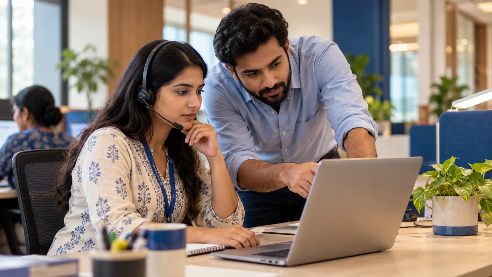 Illustrative scene of two Indian support colleagues investigating a message delivery issue at a help desk.
